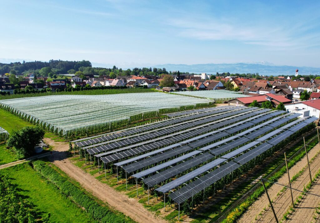 Luftaufnahme einer genehmigten Agri-PV-Anlage mit Photovoltaik-Aufständerung über einer Apfelplantage