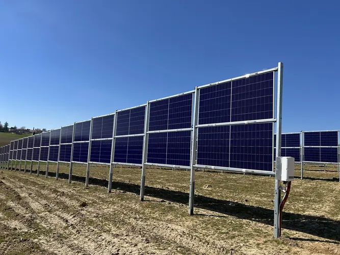 Reihe vertikal montierter Solarmodule als Zaunsystem auf einem Acker