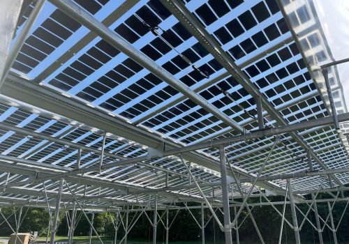 Blick von unten durch semitransparente Solarmodule auf die Unterkonstruktion einer Agri-PV-Anlage