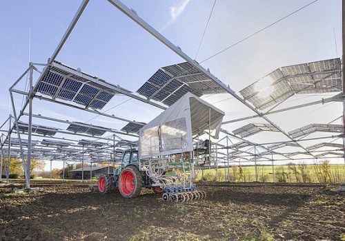 Traktor bei der Feldbearbeitung unter der Agri-PV-Anlage am Ihinger Hof